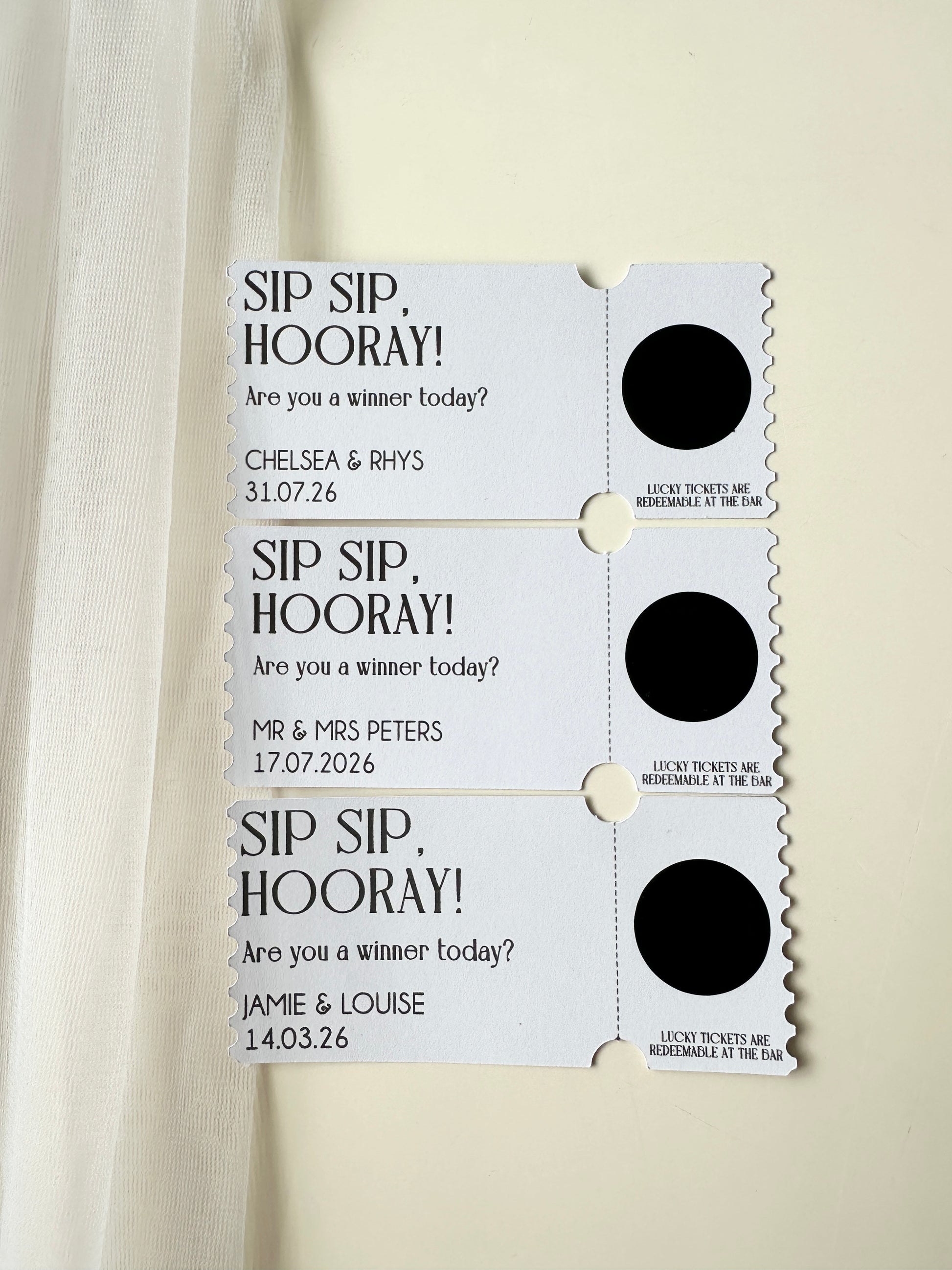 Set of three personalised tickets with black scratch ticket covering message with names and dates on a white background