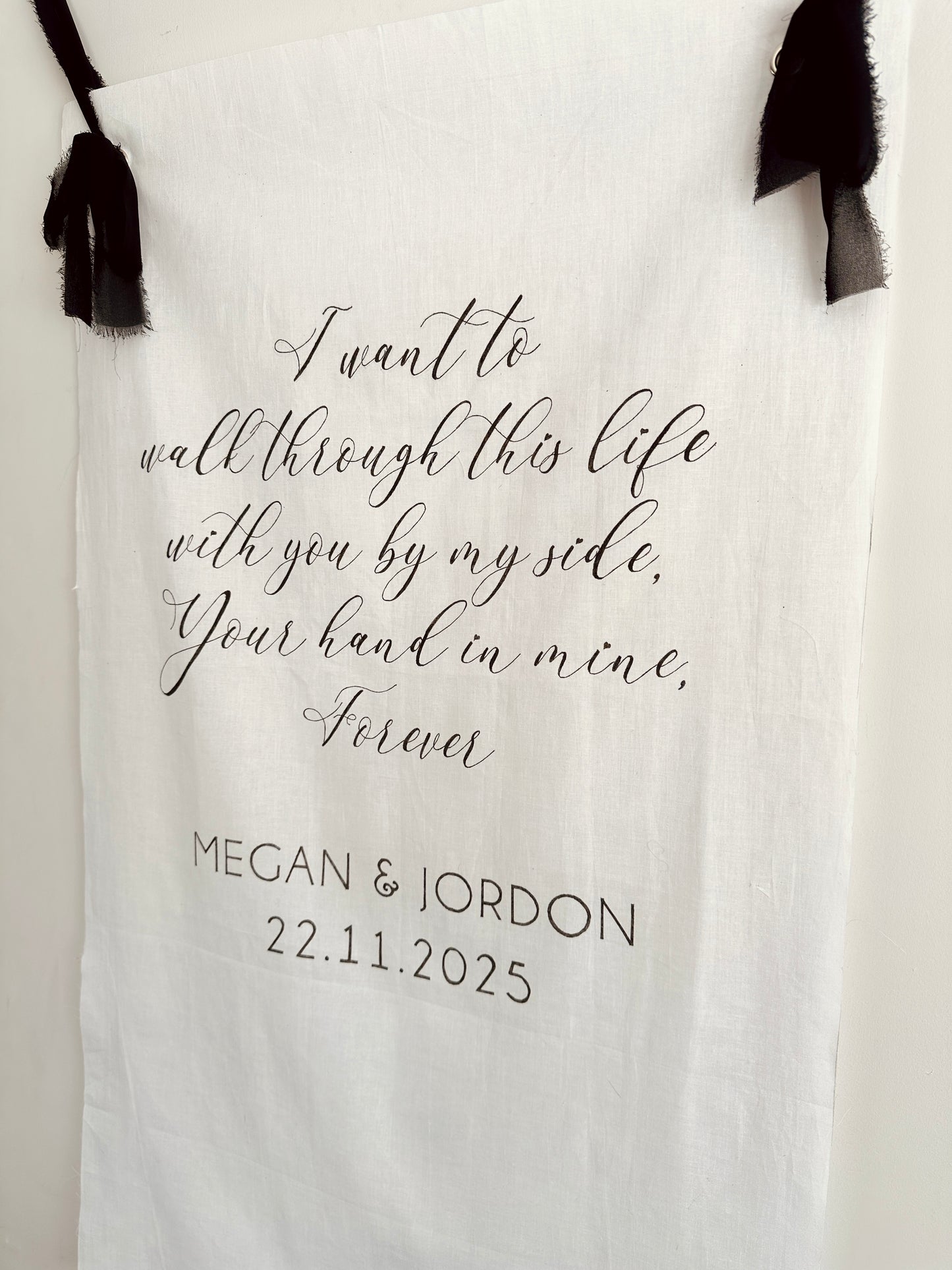 Personalised linen sign with romantic quote and names, hanging against a white background.