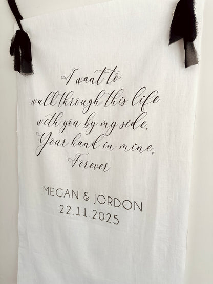 Personalised linen sign with romantic quote and names, hanging against a white background.