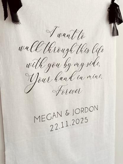 White linen wedding sign with chiffon black ribbon to hang sign, with black text and names handwritten on
