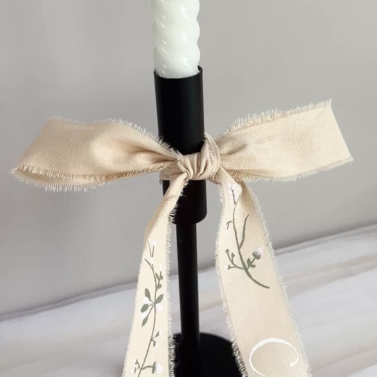 Hand painted ribbon draped on a black candle holder