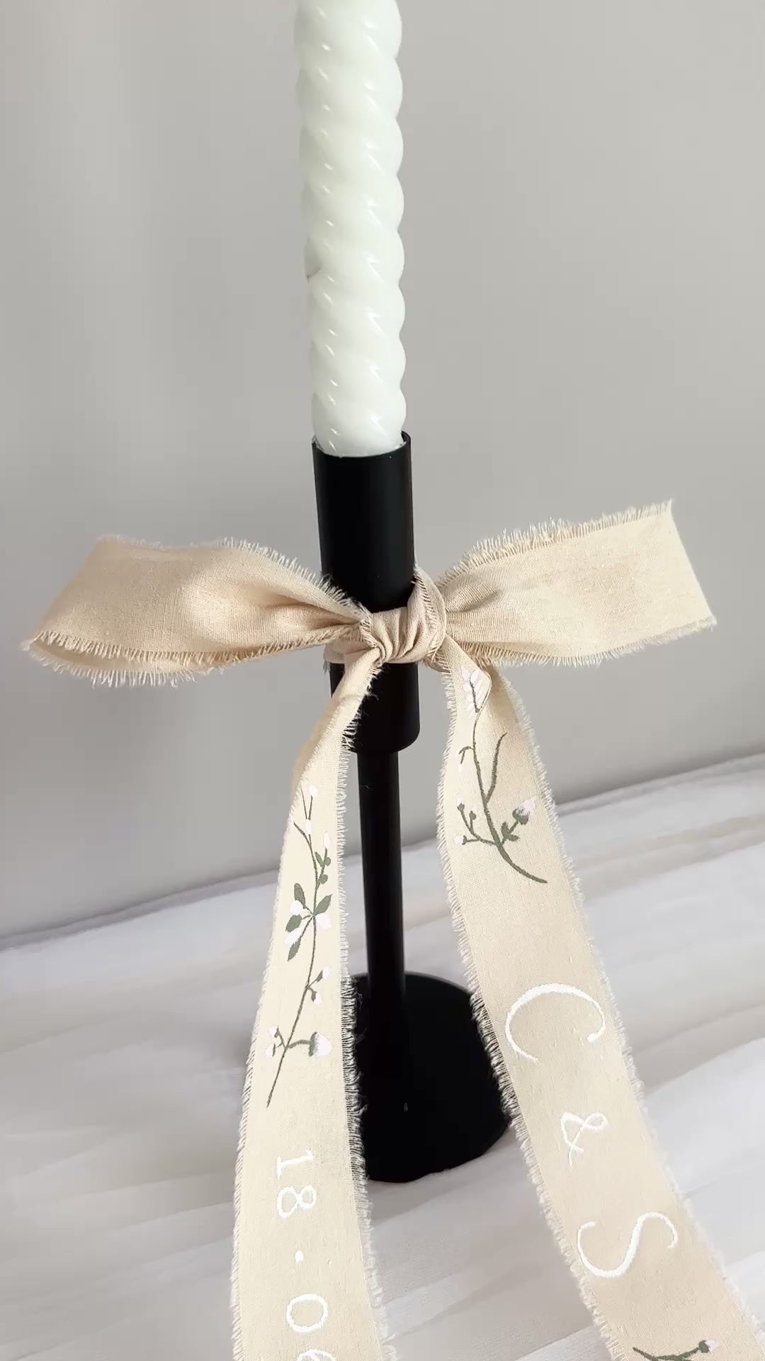 Hand painted ribbon draped on a black candle holder