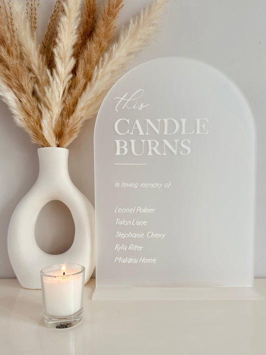 frosted acrylic arched sign, with the message 'this candle burns, in loving memory of' with names of those you wish to remember on your special day in white writing